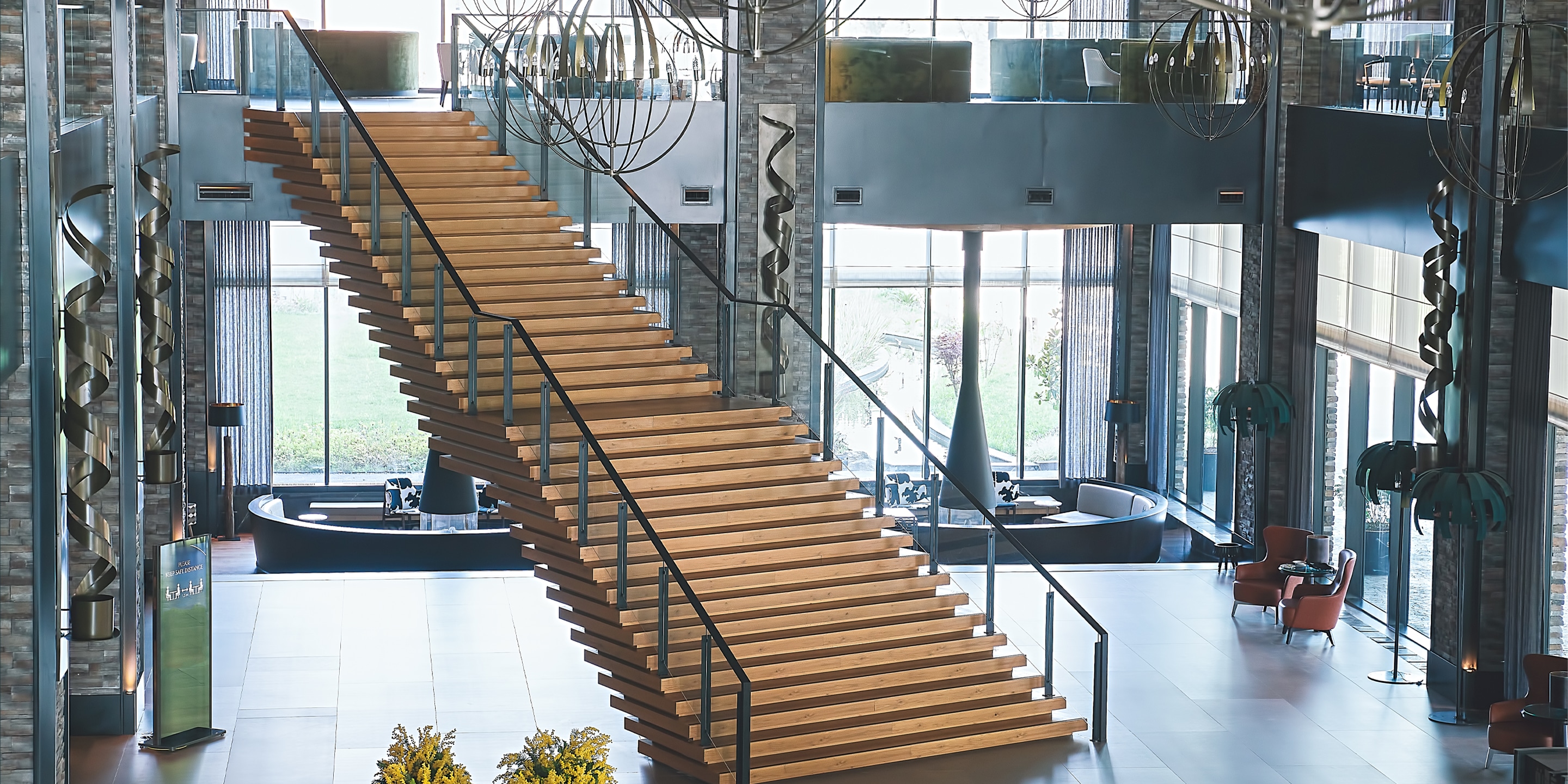 This image showcases a stunning wooden staircase as the focal point of a contemporary lobby design. 